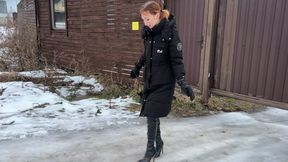 The girl went out for a walk in high-heeled boots, but her heels began to slip heavily on the ice and the girl constantly slips