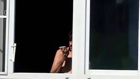 Naked girl with beautiful tits on the balcony