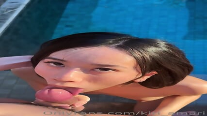 little asian slut swallowing her boyfriend's cock in the pool