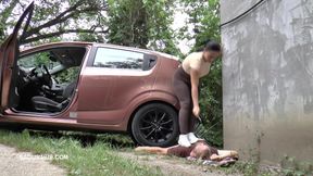 Mistress Jenna Stands on the Slave with a Car While Smoking in the Slave's Mouth