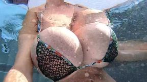 Busty Milf playing with her huge boobs in an outside pool