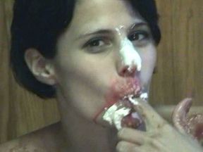 Slender brunette girlie smears her body with cherry syrup