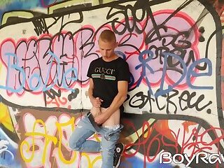 Young guy masturbates in public in front of graffiti wall