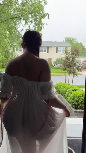 Woman in white dress standing on porch