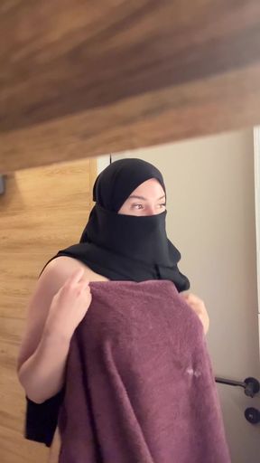 Middle Eastern woman in a hijab holding a towel