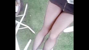 Teen Asian beauty in tight outfit and black hose strolls through lush garden
