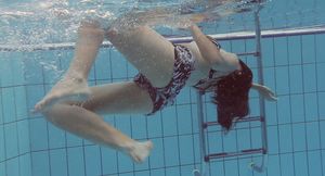Beautiful brunette white girl under water in the pool