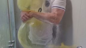 Tom takes a shower in his football kit whilst inflating and popping balloons