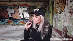 Blonde Lady Smokes an Electronic Cigarette on Stair