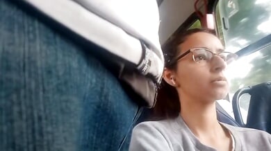 Young Brazilian woman with glasses rests on a bus while being subtly observed
