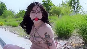 Bound Asian Girl Hops Outdoors