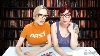 Redhead and blonde with glasses explore dildos together in a quiet library